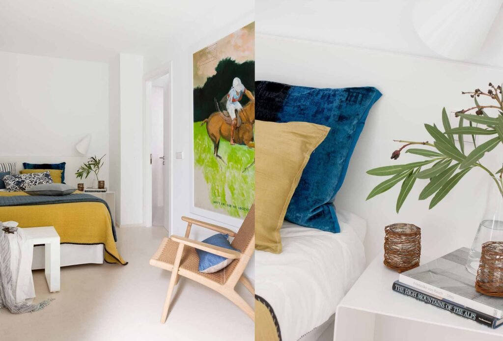 Dormitorio con colcha mostaza, butaca de madera y cuadro grande, y detalle de cojines azul y mostaza