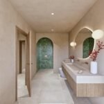 Baño con ducha en nicho arqueado de azulejo verde, paredes beige, doble grifería y espejo orgánico iluminado